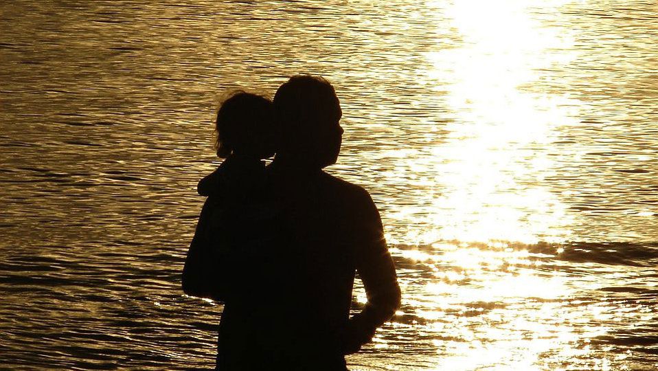 a gay man's daughter: silhouette of a man holding up his daughter