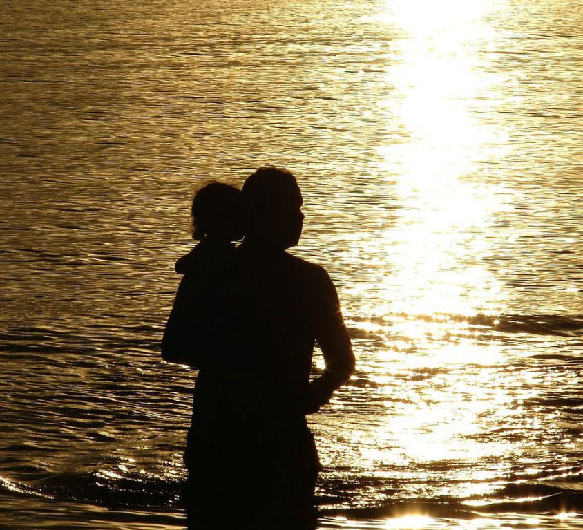 a gay man's daughter: silhouette of a man holding up his daughter