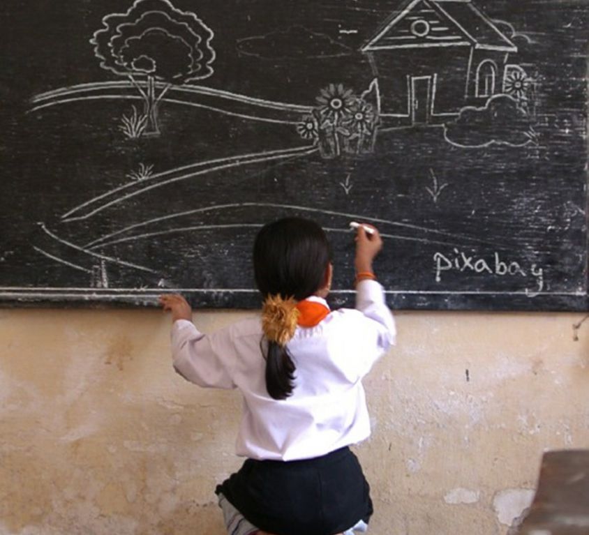 picture of a young girl writing on the blackboard