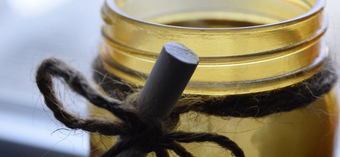 An image of a DIY candle jar with a jute ribbon and a chalk tied around it