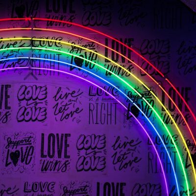 An image of a wallpaper with stickers that says “Love Wins”, “Love is love” “Love is a Human Right” and “Support Love”. There are six thin lines in the form of a rainbow with pride colours