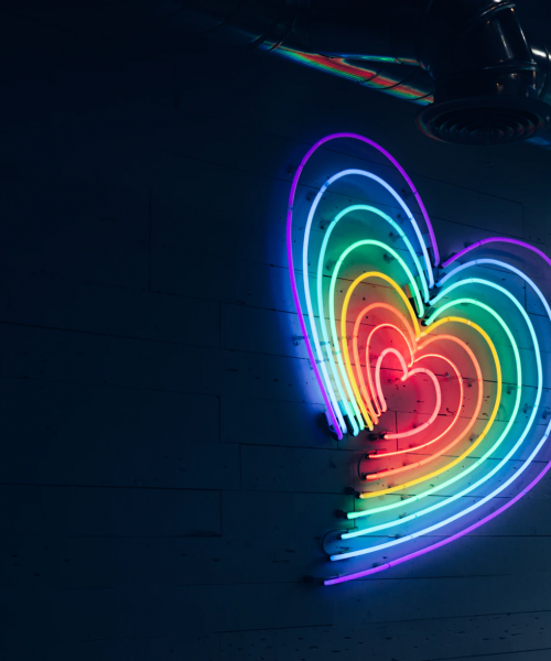 A picture of a rainbow coloured heart hanging on a wall