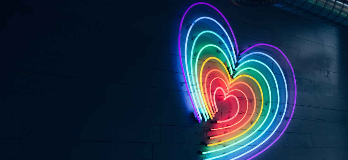A picture of a rainbow coloured heart hanging on a wall