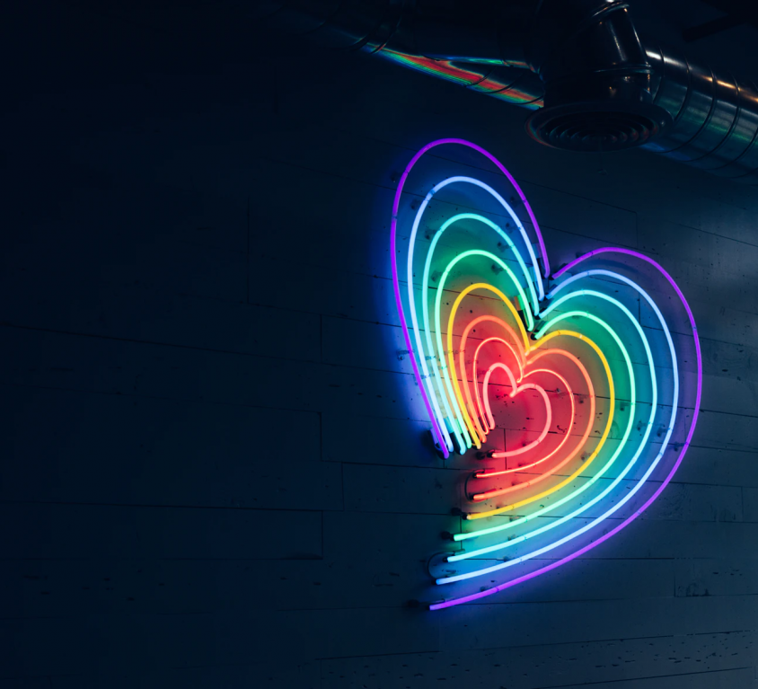 A picture of a rainbow coloured heart hanging on a wall