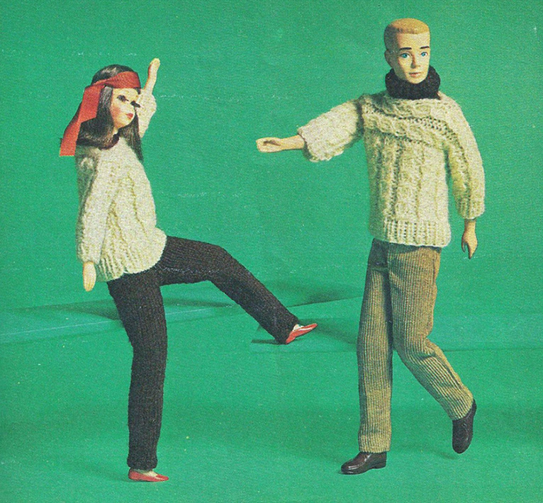 Image of two dolls swaying their legs and arms. The doll on the left has long hair and is wearing a red coloured head scarf on its head and a white sweater and black pants. The doll also has makeup on its face. The doll on the rights has short hair and is wearing a white sweater with grey pants. The doll has a black woolen scarf around its neck