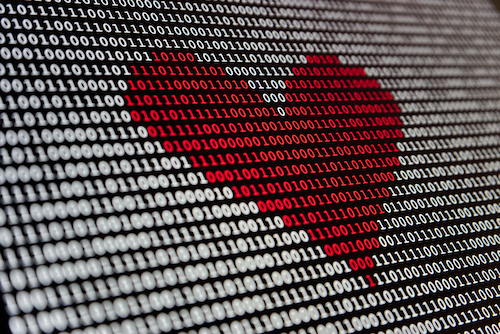 On a black background, binary digits are displayed in white, as if on a screen. In the middle is a red heart shape, made from the binary digits.