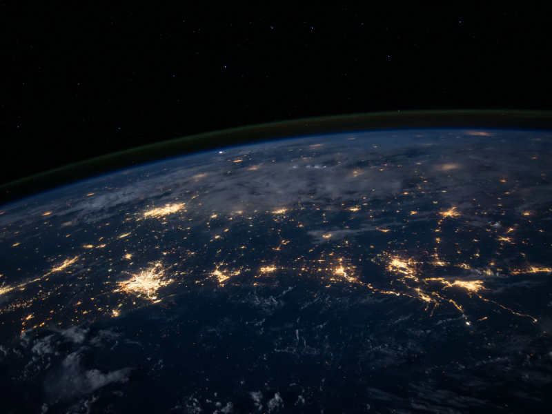 An image of a part of the Earth as seen from outer space. Only a semicircular part of the Earth has been captured, with a black background. On the surface of the Earth that is visible are golden branch-link lines and patches of golden light to indicate connectivity.