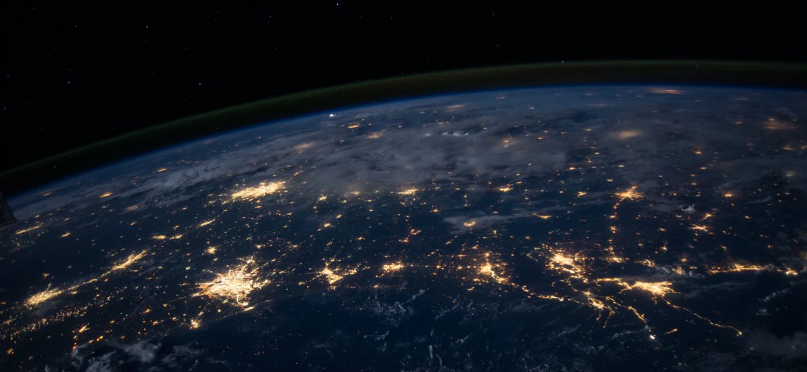 An image of a part of the Earth as seen from outer space. Only a semicircular part of the Earth has been captured, with a black background. On the surface of the Earth that is visible are golden branch-link lines and patches of golden light to indicate connectivity.