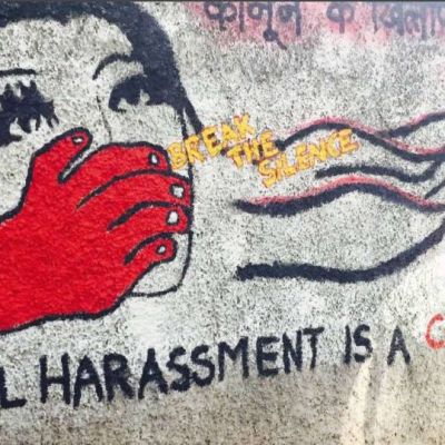 एक महिला के मुँह को ढक रहे एक लाल रंग के हाथ का भित्ति चित्र। चित्र के साथ पीले रंग में सन्देश है: 'चुप्पी तोड़ों', उसके नीचे बड़े अक्षरों में लिखा है: 'यौन उत्पीड़न एक अपराध है' और उसके ऊपर: 'कानून के ख़िलाफ़'।