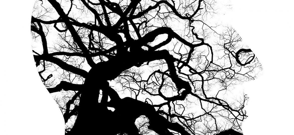 A graphic illustration with a black, inky tree with branches outlined by a silhouette of a face.