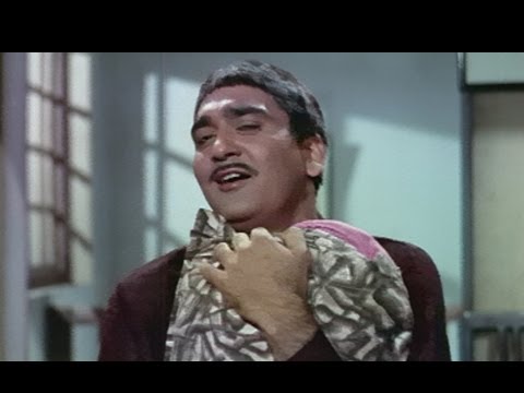 A screengrab from the Hindi movie Padosan showing a man holding a pillow.