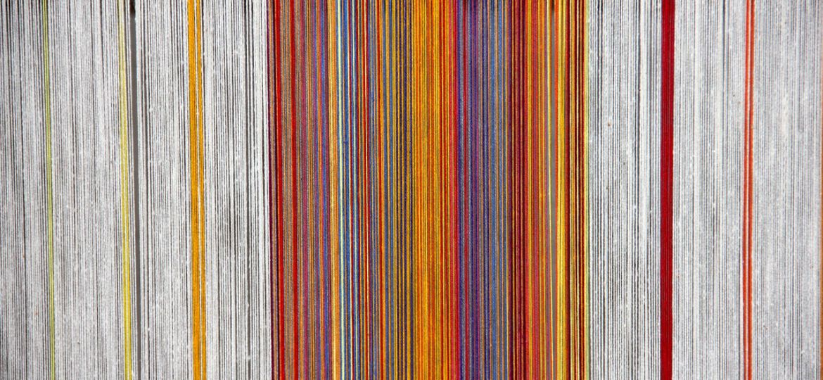 A photograph of colourful weaves of threads.