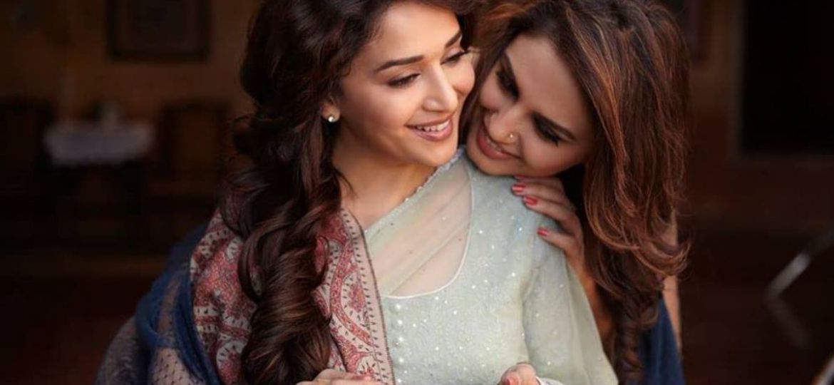 A shot from the film featuring the two female leads, one is preparing a paan with the other’s face resting on her shoulder. Both the women are smiling.