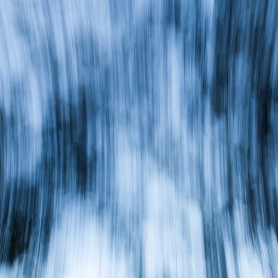 An abstract photo of blurred blue and white vertical lines that are spanning outwards
