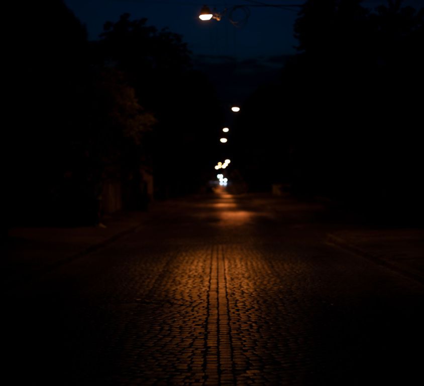A dark path lit subtly by street lights