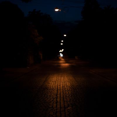 A dark path lit subtly by street lights