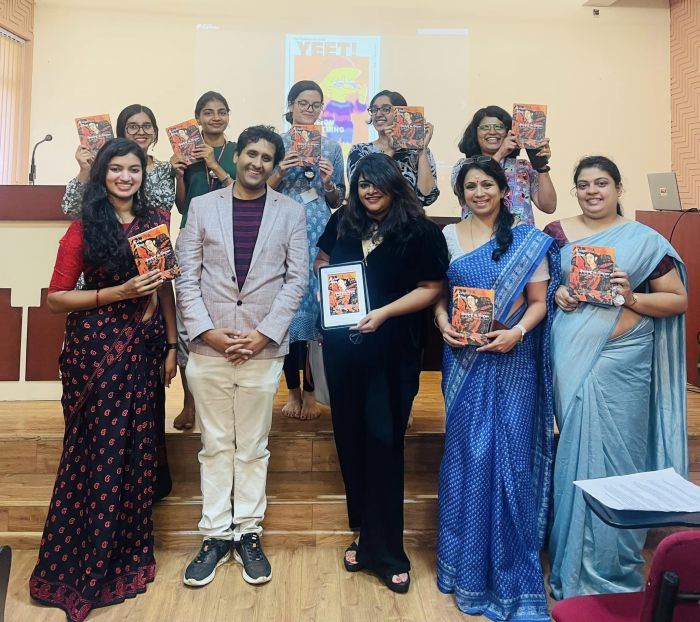 A group of 10 people standing in two rows holding Kiran Bhat's Speaking in Tongues - a collection of poetry. Kiran Bhat is standing in the middle of the first row.