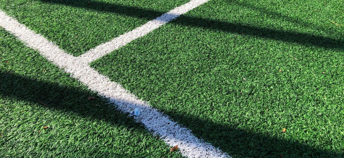 A close-up of a green playing field with dividing lines.