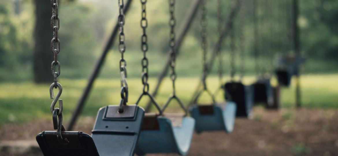 Selective focus shot of outdoor playground swings.