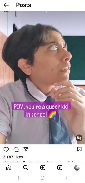 A screenshot of a reel posted by the Instagram account @shorthairedbrownqueer. A person with short hair and wearing a school shirt and tie is looking to their right side with eyes wide open and an expression of shock. One hand is touching the chin slightly. The image is has a text overlay that reads, "POV: you're a queer kid in school" followed by a rainbow emoji.