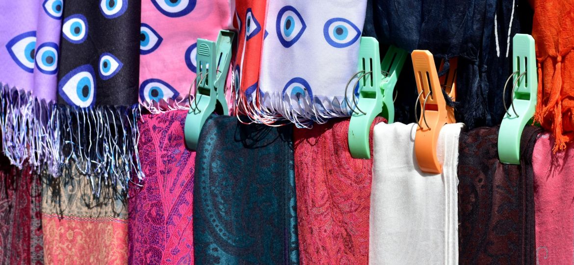 A close-up of a colourful group of hanging scarves.