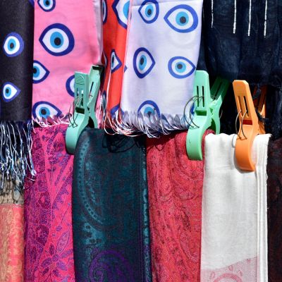 A close-up of a colourful group of hanging scarves.