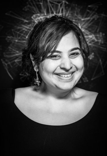 A black-and-white close-up of Padmini Ray Murray smiling.