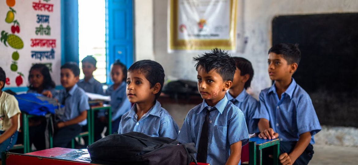 a group of young children sitting in a classroom