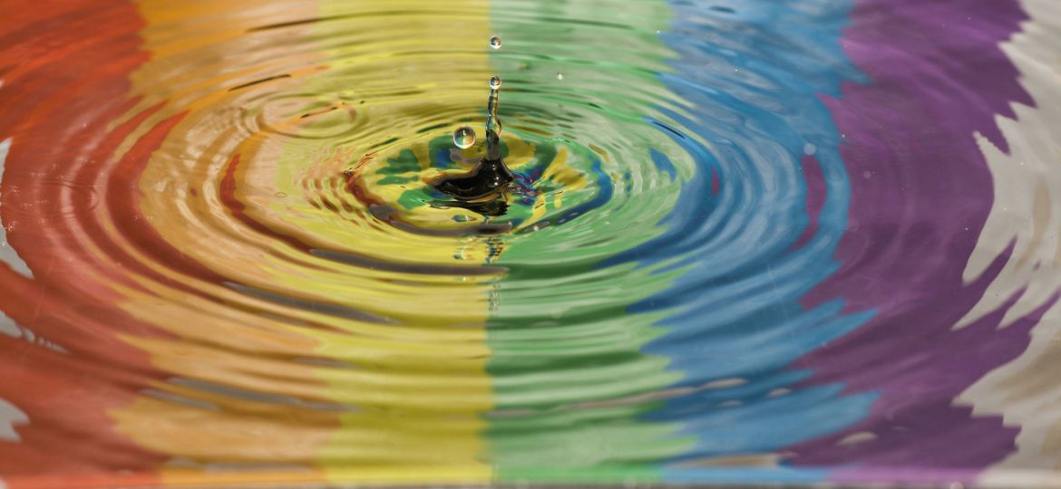 time lapse photography of water ripple prominently showing a rainbow