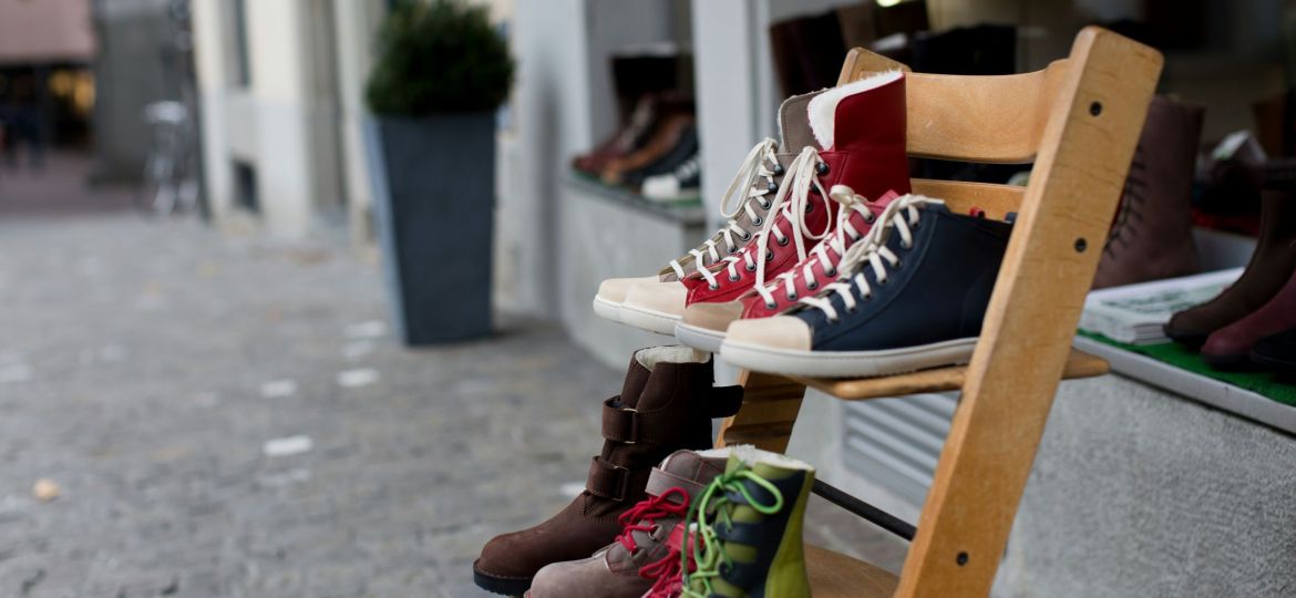assorted-color pairs of footwear on brown wooden 2-layer shoe rack