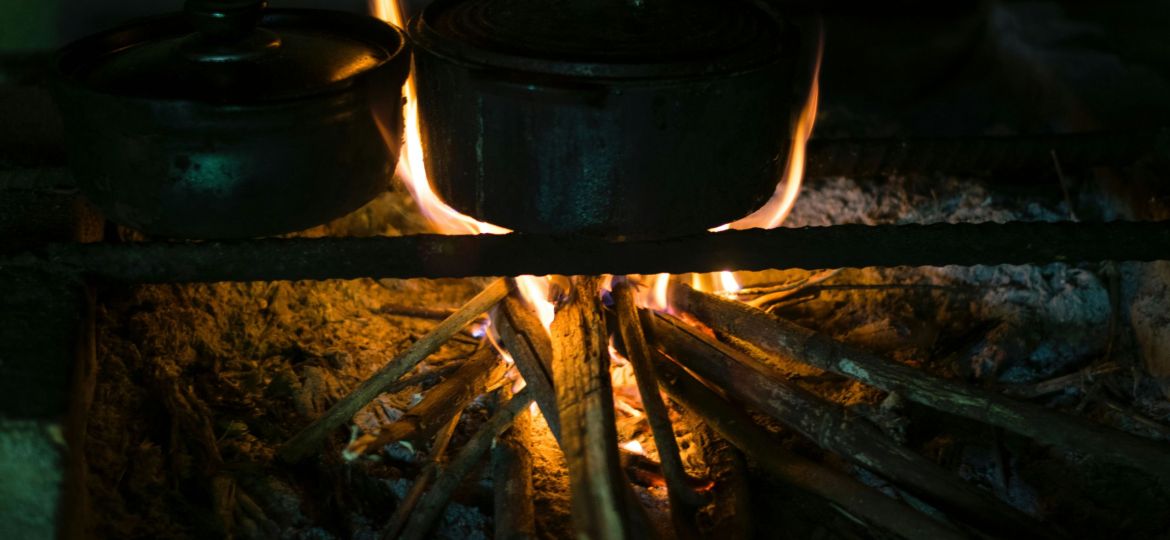 A black pot on a firepit at night