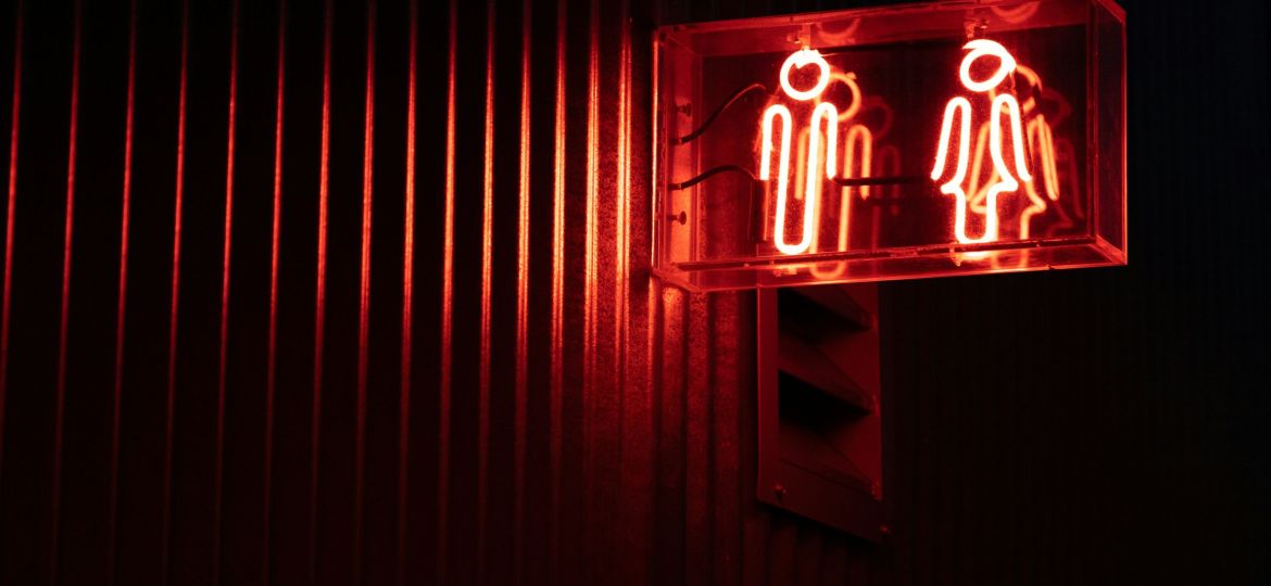 gender bathroom signage in red neon lighting