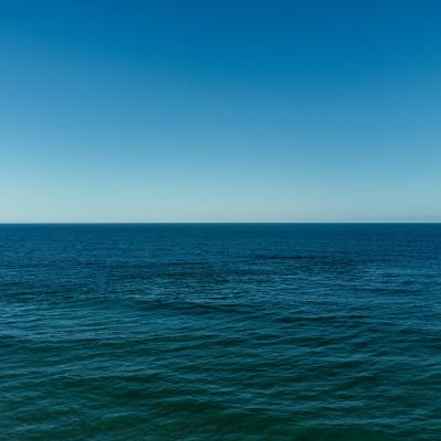 A photograph of the blue sea and the horizon in the distant.