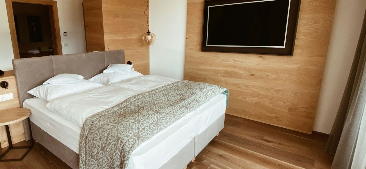 A hotel bedroom with the bed made in white linen