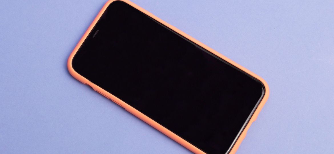 A iPhone lying on a purple surface