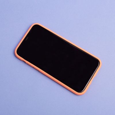 A iPhone lying on a purple surface