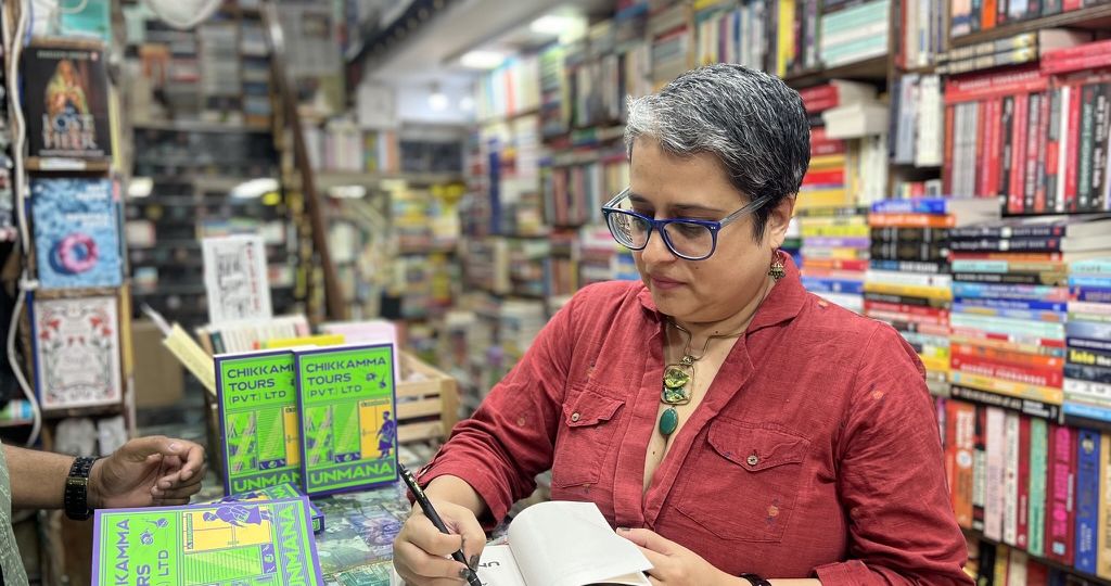 Unmana signing a copy Chikkamma Tours (Pvt.) Ltd in a bookshop