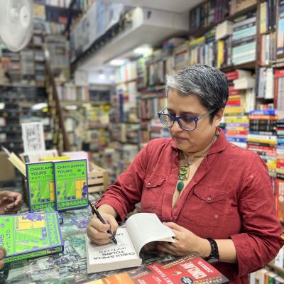 Unmana signing a copy Chikkamma Tours (Pvt.) Ltd in a bookshop